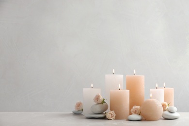 Photo of Beautiful composition with candles on table against grey background. Space for text