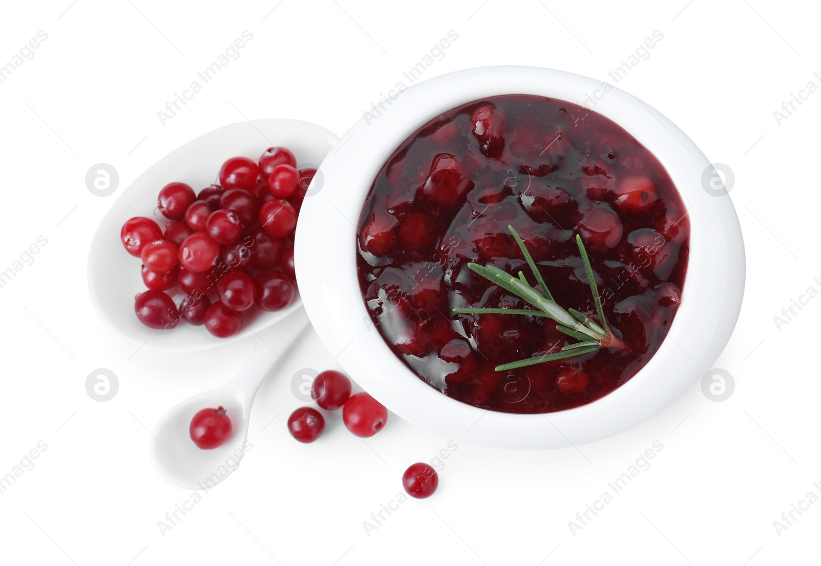 Photo of Cranberry sauce in bowl, fresh berries, spoon and rosemary isolated on white, top view