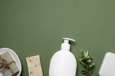 Soap bars and bottle dispenser on green background, flat lay. Space for text