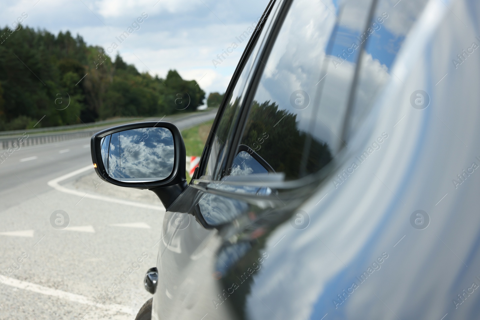 Photo of New black modern car outdoors, closeup of side rear view mirror