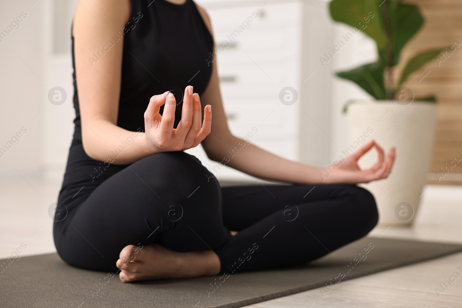 Photo of Beautiful girl meditating on yoga mat at home, closeup