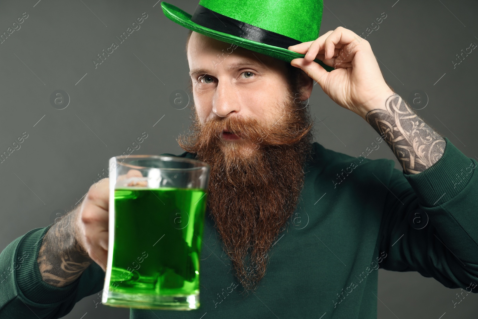 Photo of Man with green beer on grey background. St. Patrick's Day celebration