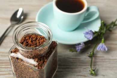 Jar of chicory granules on white wooden table, closeup. Space for text