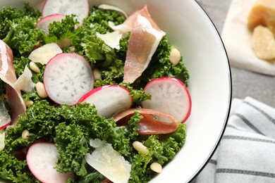 Photo of Tasty fresh kale salad on grey table, closeup