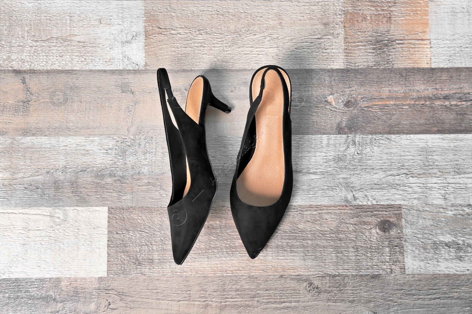 Photo of Pair of female shoes on wooden background, top view