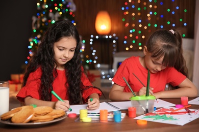 Photo of Little children drawing pictures at home. Christmas celebration