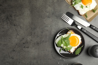 Photo of Delicious sandwich with arugula and fried egg on grey table, flat lay. Space for text