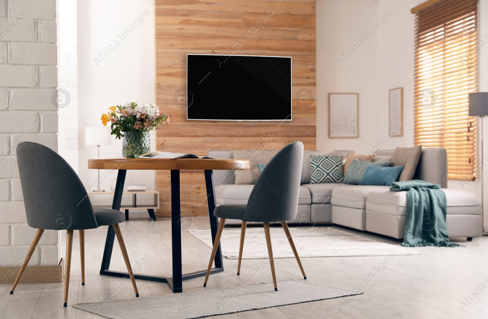 Image of Modern wide screen TV on wall in room with stylish furniture  