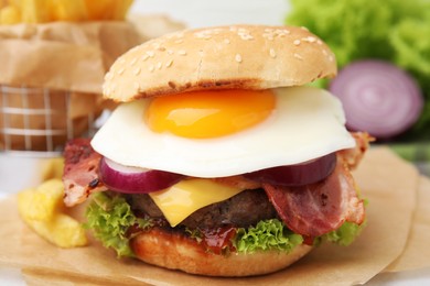 Photo of Delicious burger with fried egg on table, closeup