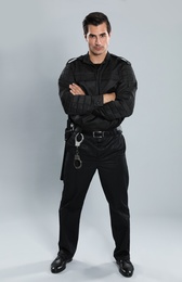 Male security guard in uniform on grey background