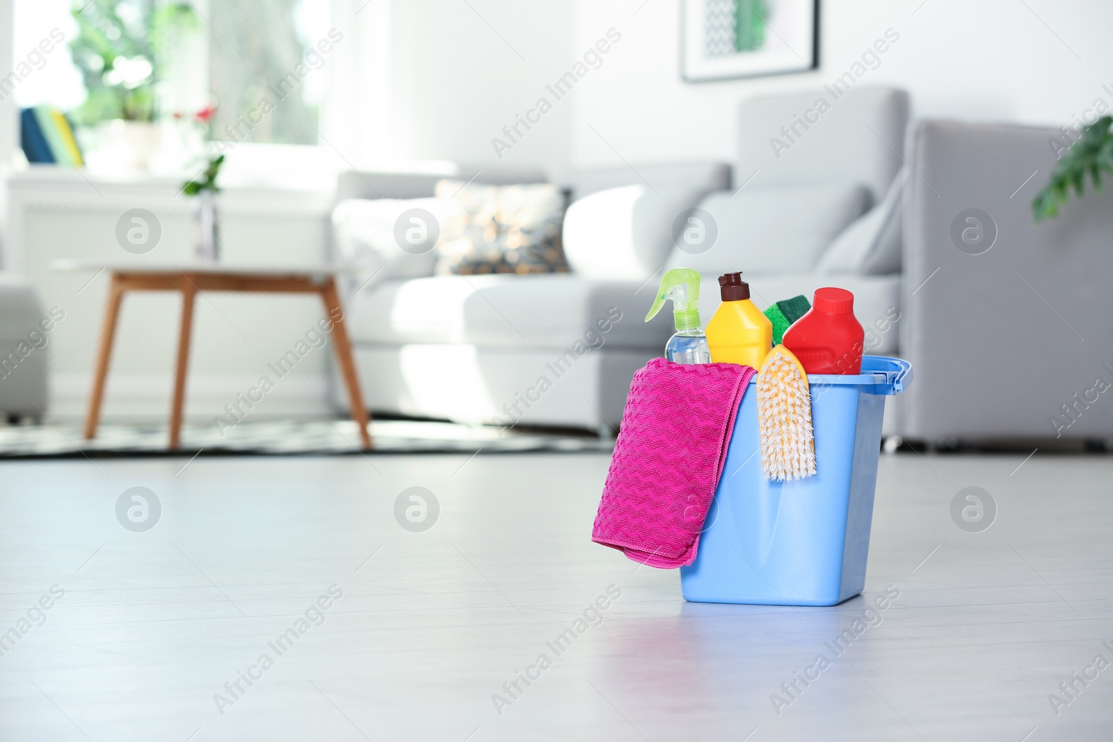 Photo of Bucket with cleaning supplies on floor indoors