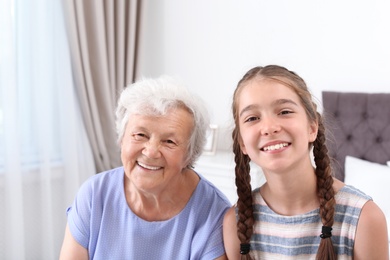 Photo of Happy cute girl with her grandmother at home