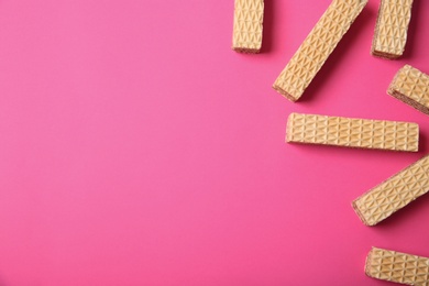 Flat lay composition with delicious crispy wafers on pink background. Space for text