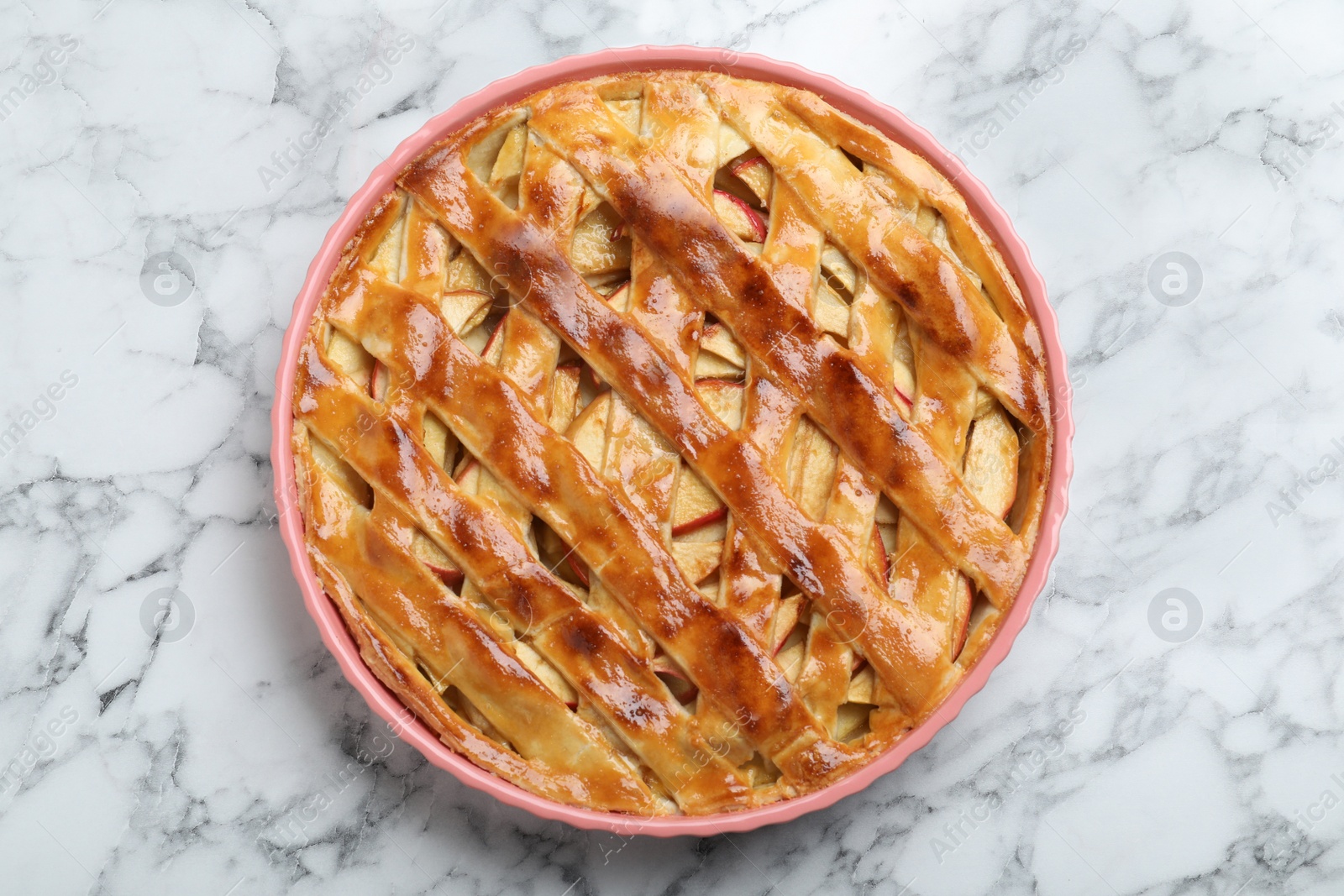 Photo of Fresh traditional apple pie on white marble table, top view