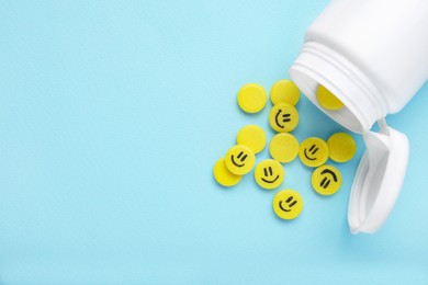 Yellow antidepressants with happy emoticons and medical bottle on light blue background, flat lay. Space for text