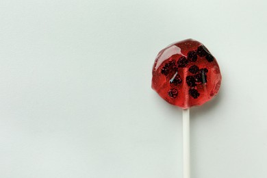 Photo of Sweet colorful lollipop with berries on white marble table, top view. Space for text