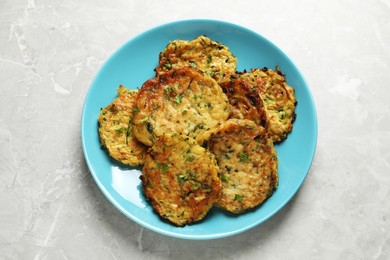 Photo of Delicious zucchini pancakes on grey table, top view