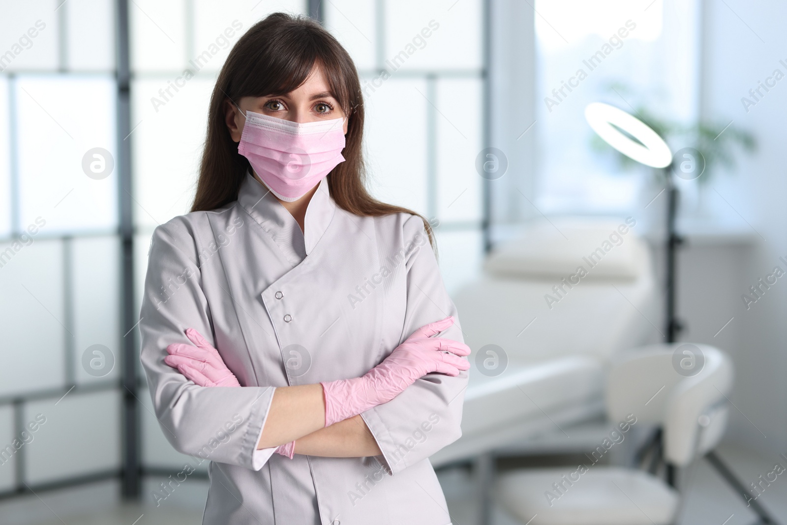 Photo of Cosmetologist in medical uniform in clinic, space for text