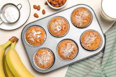 Photo of Flat lay composition with homemade banana muffins and milk on white wooden table