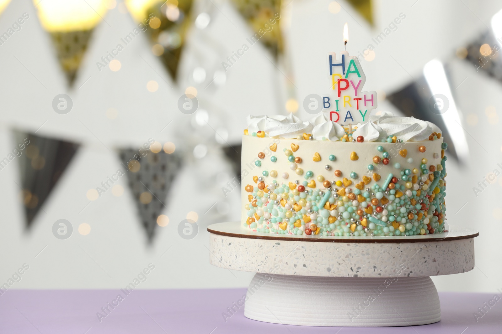 Photo of Beautiful birthday cake with burning candle on violet table. Space for text