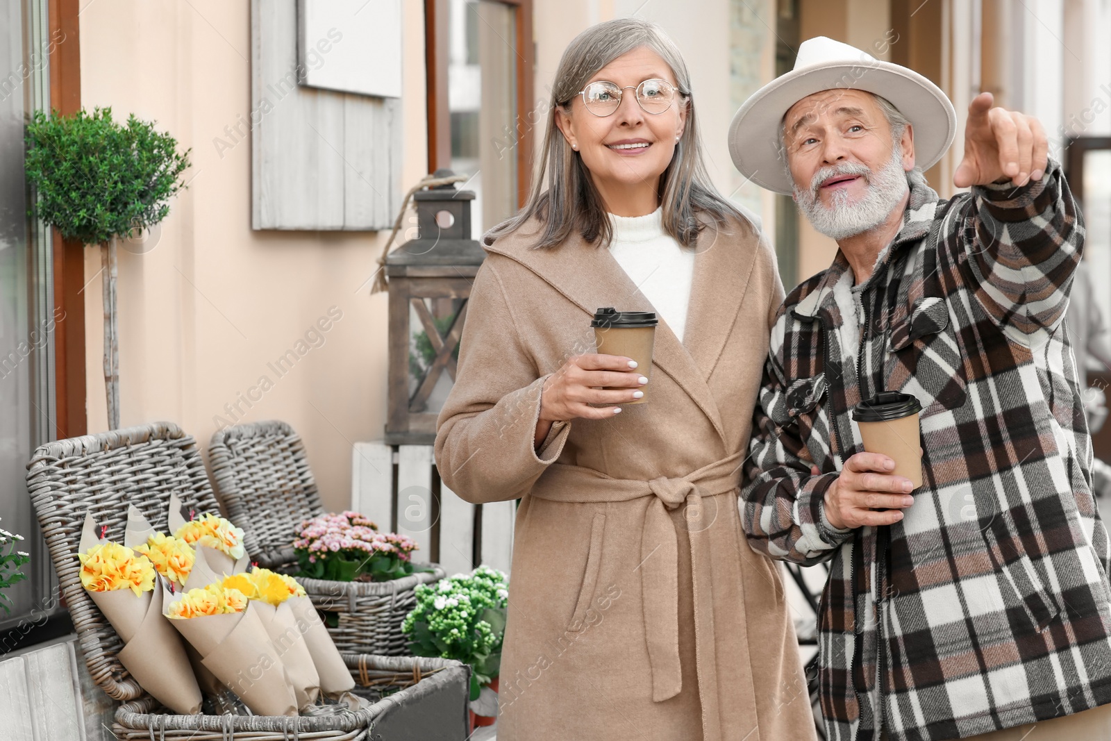 Photo of Affectionate senior couple drinking coffee outdoors, space for text