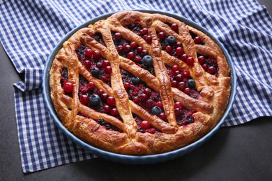 Photo of Delicious currant pie and fresh berries on grey table
