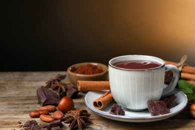 Photo of Composition with yummy hot chocolate in cup on wooden table, space for text