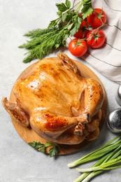 Photo of Tasty roasted chicken with different products on light grey table, flat lay