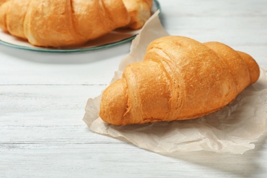 Photo of Tasty croissant on wooden table