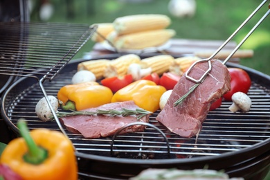 Photo of Cooking fresh food on barbecue grill outdoors, closeup