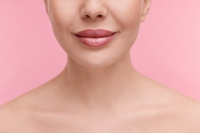 Woman with beautiful lips on pink background, closeup