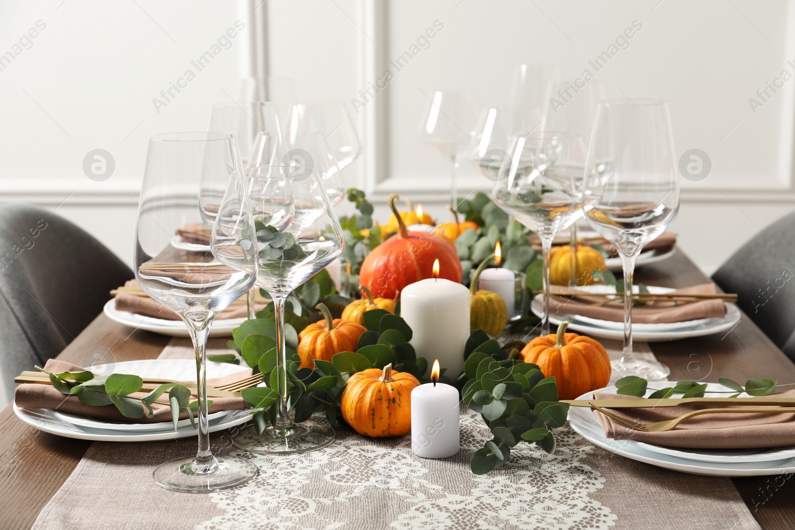 Photo of Beautiful autumn table setting. Plates, cutlery, glasses, pumpkins and floral decor