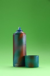 Photo of Spray paint can with cap on green background