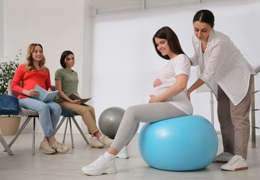 Photo of Group of pregnant women with midwife at courses for expectant mothers indoors