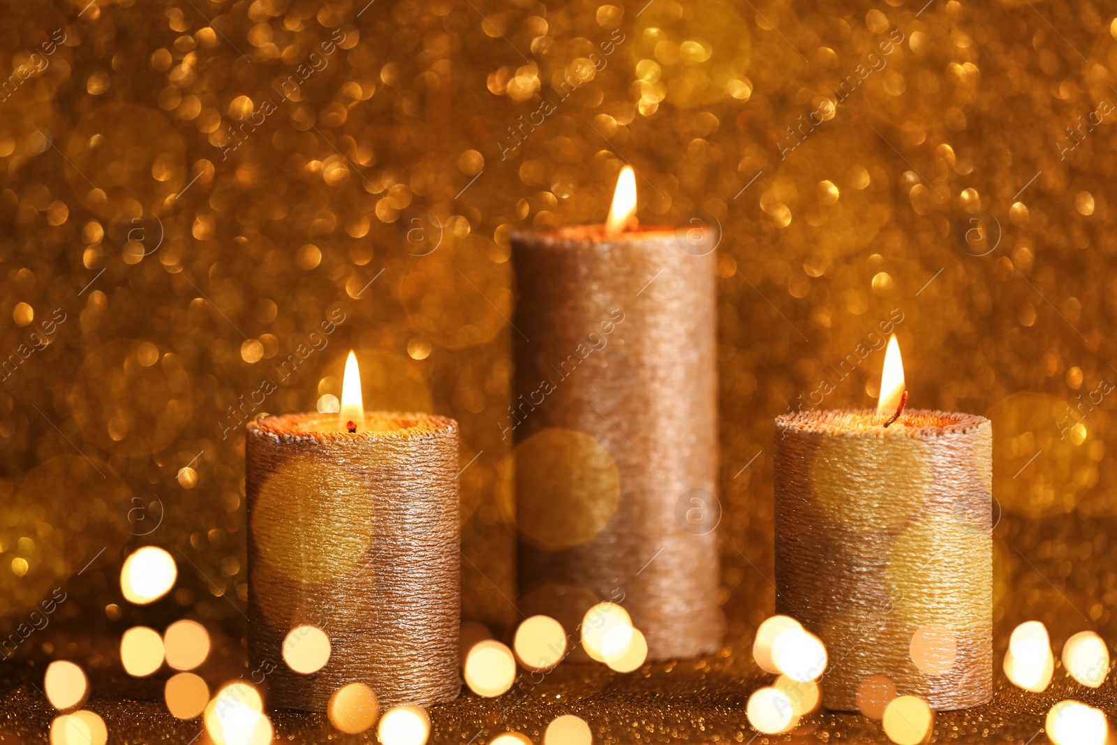 Image of Burning candles on golden background, bokeh effect