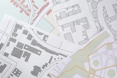 Many different cadastral maps of territory with buildings as background, top view