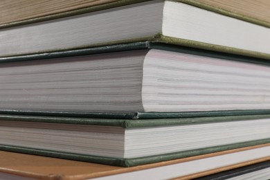 Photo of Stack of many different hardcover books as background, closeup