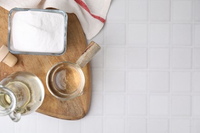 Vinegar and baking soda on white tiled table, top view. Space for text