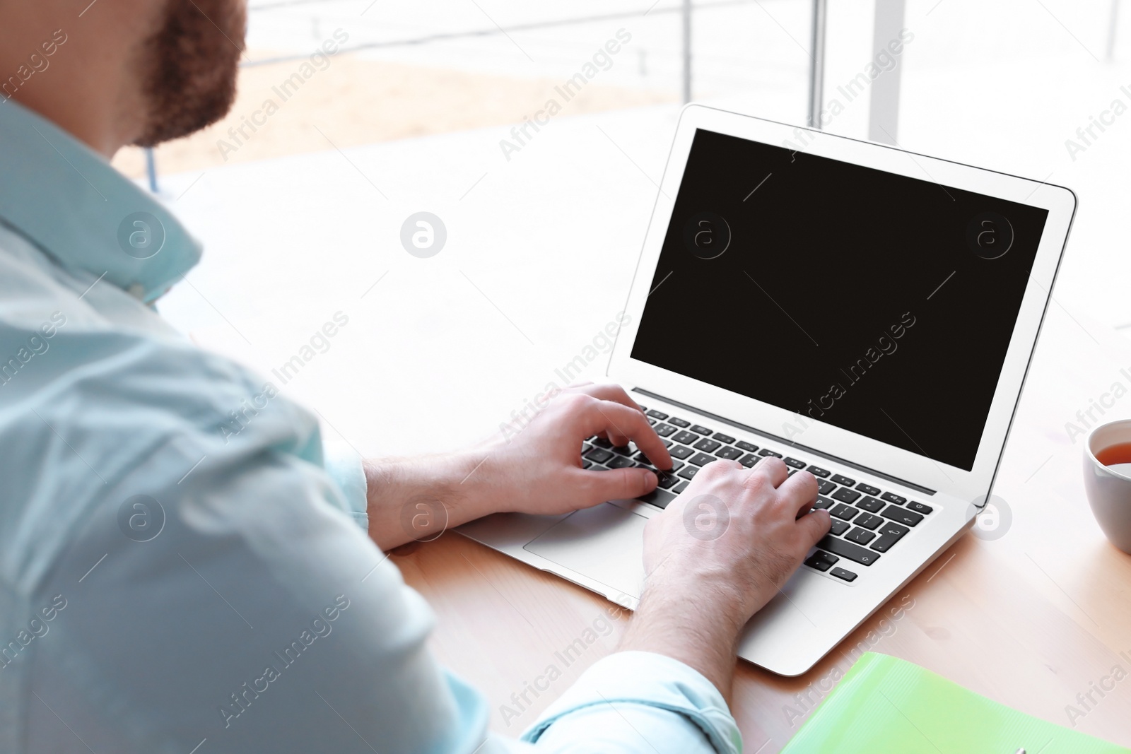 Photo of Young man working with laptop at desk. Home office