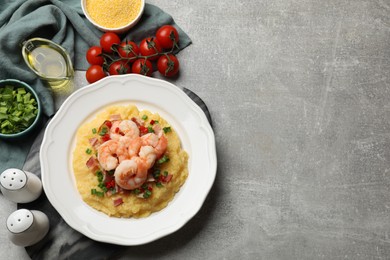 Photo of Plate with fresh tasty shrimps, bacon, grits, green onion and pepper on gray textured table, flat lay. Space for text