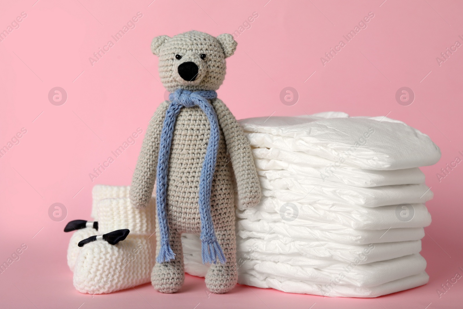 Photo of Diapers and baby accessories on pink background