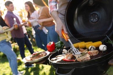 Photo of Group of friends having barbecue party outdoors, closeup