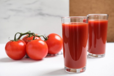 Delicious fresh tomato juice on white table