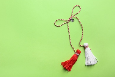 Traditional martisor on green background, top view with space for text. Beginning of spring celebration