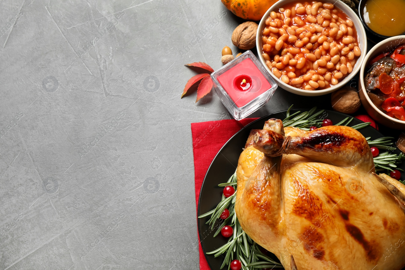 Photo of Traditional Thanksgiving day feast with delicious cooked turkey and other seasonal dishes served on grey table, flat lay. Space for text