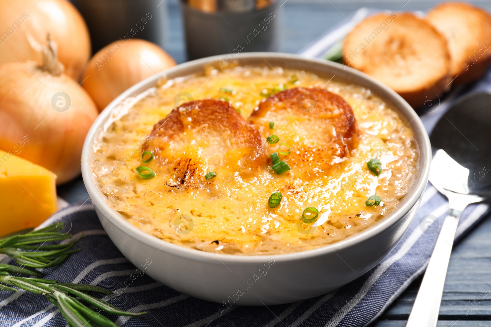 Photo of Tasty homemade french onion soup served on table, closeup