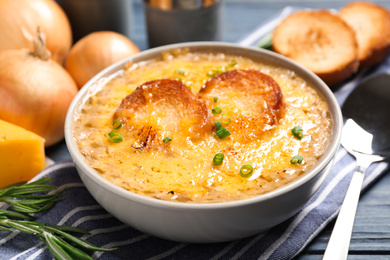 Tasty homemade french onion soup served on table, closeup