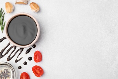 Photo of Organic balsamic vinegar and cooking ingredients on white table, flat lay. Space for text