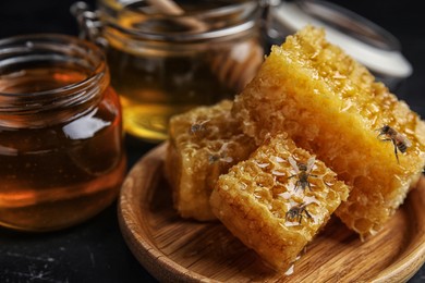 Image of Tasty fresh honey and bees on black table, closeup