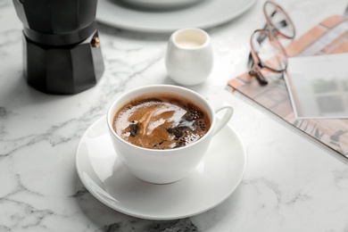 Cup of delicious hot coffee on table